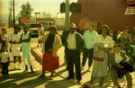 People on sidewalk watching parade by Henry Hooks